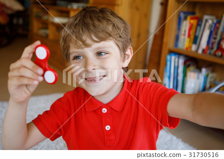 School kid playing with Tri Fidget Hand Spinner 31730516