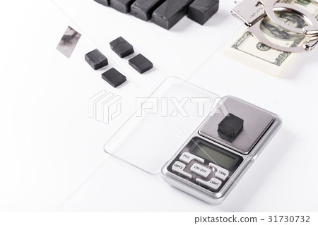Blocks of hashish on digital scales over white Blocks of hashish on digital scales over white 31730732