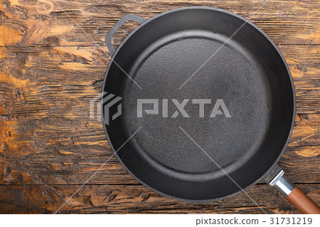 a cast-iron frying pan on a wooden background 31731219