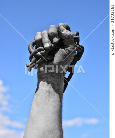 Dirty hand with chain against the blue sky 31732163