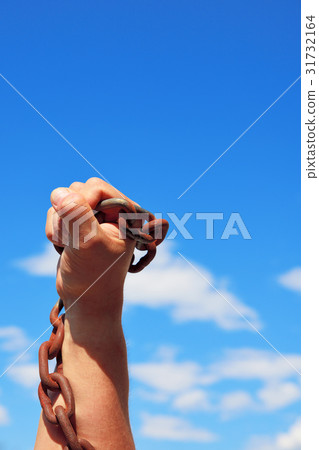 male hand holds a rusty metal chain 31732164