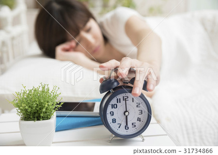 Wake up image of woman who stops alarm clock in the morning Wake up image of woman who stops alarm clock in the morning 31734866