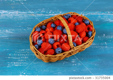 Raspberry with blueberry in basket on an old blue Raspberry with blueberry in basket on an old blue 31735004