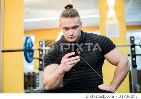 Young handsome man using phone while having 31736875