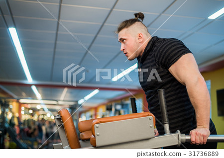 Focused man doing dips in the gym 31736889