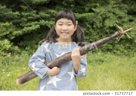 A girl holding a bamboo shoot A girl holding a bamboo shoot 31737717