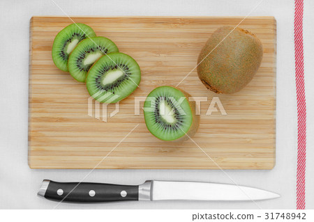 Sliced kiwi on a wooden board. Top view. 31748942