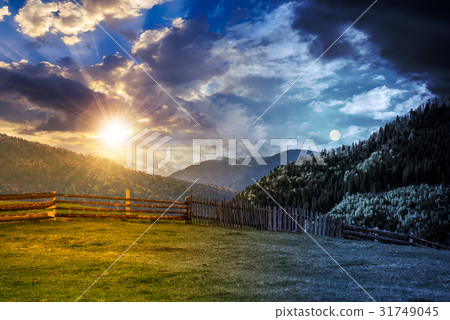 fence through meadow in mountains, day night fence through meadow in mountains, day night 31749045