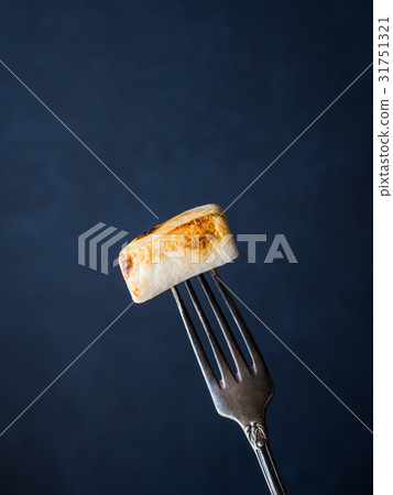 Smoked marshmallow on fork on dark background 31751321