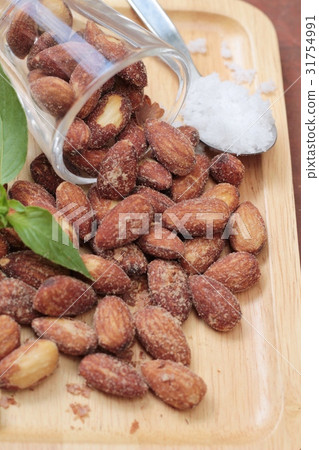 Almonds nuts with salt on wood background. Almonds nuts with salt on wood background. 31754991