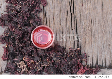 Dry roselle and roselle juice on wood background. Dry roselle and roselle juice on wood background. 31755013