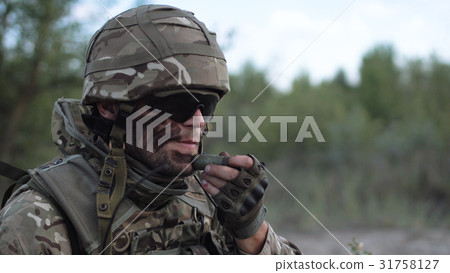 Man putting camouflage on face 31758127