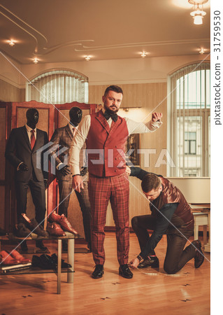 Tailor measuring client for custom made suit 31759530