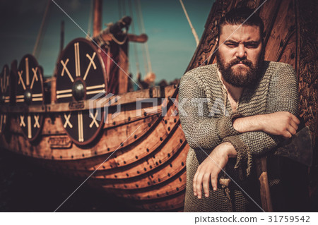 Viking with axe standing near drakkar on the 31759542