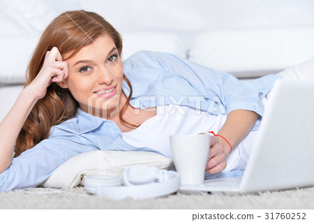 young woman lying in front of laptop 31760252