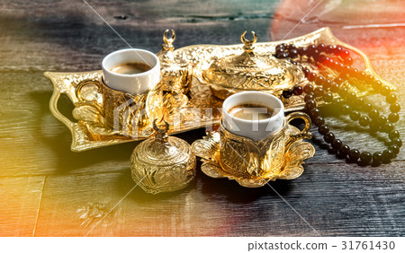 Golden coffee cups rosary beads wooden background 31761430