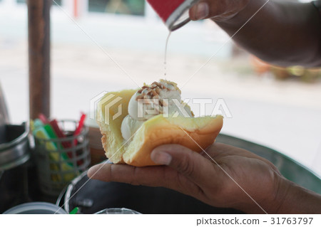 Scooping coconut Ice-cream on bread 31763797
