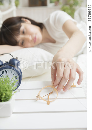 A woman taking glasses to wake up A woman taking glasses to wake up 31766452