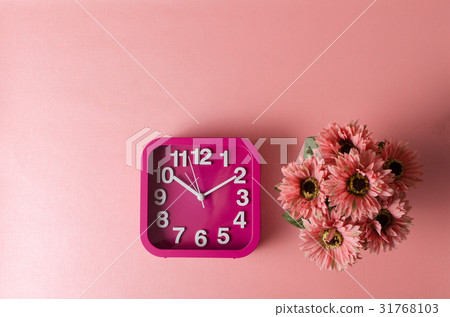 Clock and Gerbera flower on pink background 31768103