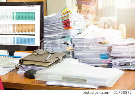 Pile of unfinished documents on office desk 31768872