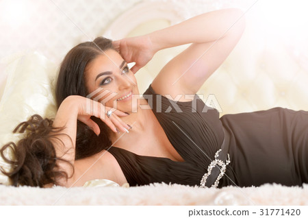 young woman lying on bed young woman lying on bed 31771420