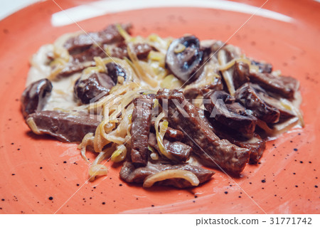 Stew with mushrooms and onions in sauce. 31771742