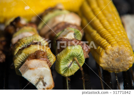 close on raw meat with fruits on the grill 31771842