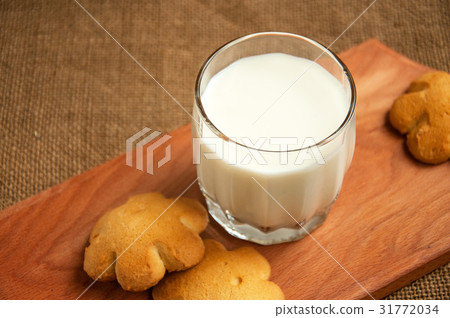 A glass of milk with cookies on a wooden board  31772034