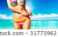 Summer body. A woman standing on the beach with a colorful bikini 31773962