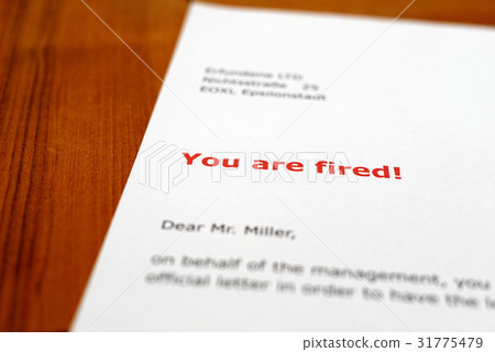 A letter on a wooden desk - you are fired A letter on a wooden desk - you are fired 31775479