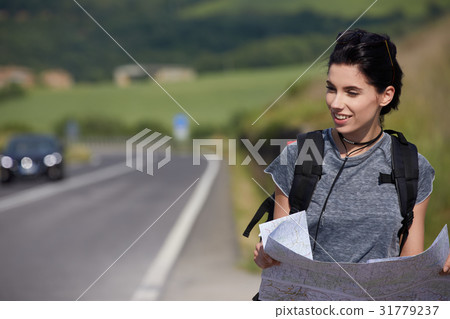 girl holding map with backpack in the road and Tuscany backgroun 31779237