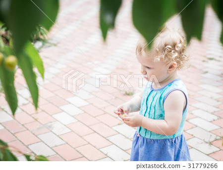 Little girl in the home garden. 31779266