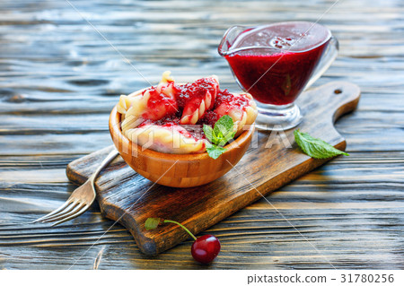 Homemade dumplings with cherries in a wooden bowl. 31780256