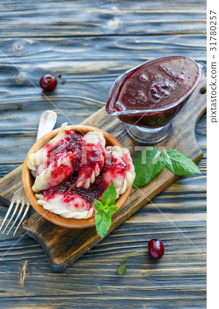 Dumplings with cherry and sweet berry sauce. 31780257