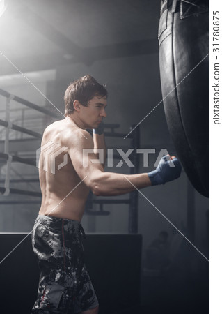 Male fighter smash punching bag 31780875