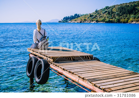Girl with backpack on pier on the beach near 31781086