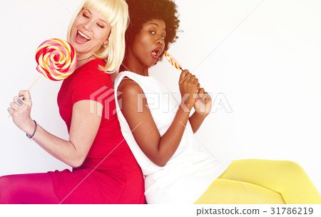 Diverse women friends happiness smiling and eating lollipop Diverse women friends happiness smiling and eating lollipop 31786219