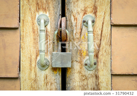 Old rusted lock on a wooden door Old rusted lock on a wooden door 31790432