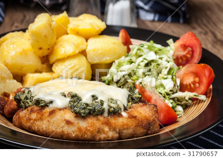 Fried chicken fillet with spinach and cheese. 31790657
