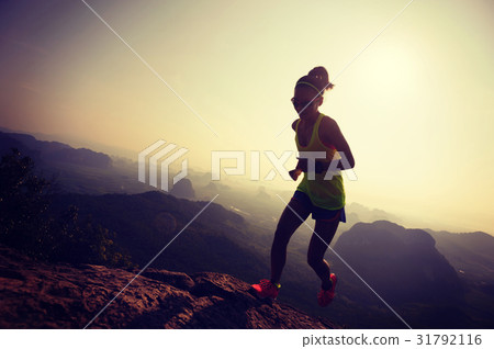 young woman running up on mountain top 31792116