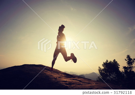 silhouette of young woman running on mountain top 31792118
