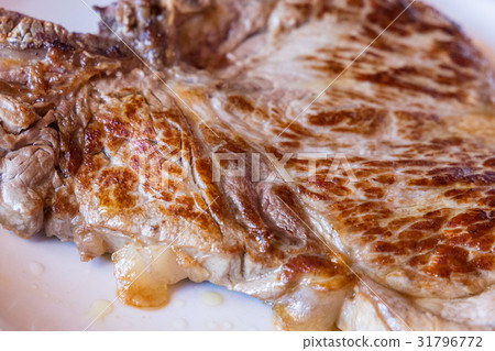 Closeup of a grilled steak on white plate Closeup of a grilled steak on white plate 31796772