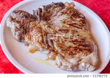 Closeup of a grilled steak on white plate Closeup of a grilled steak on white plate 31796774