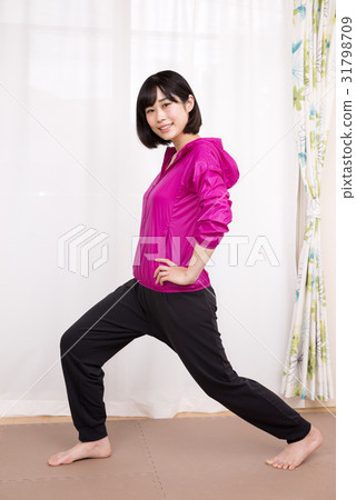 一個女人側身伸展她的雙腿 一個女人側身伸展她的雙腿 31798709