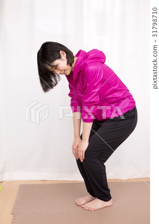 A woman stretching her knees in landscape orientation 31798710