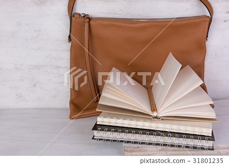 Notebooks and brown leather bag on grunge wood 31801235