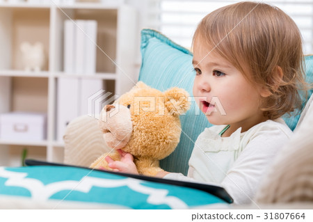 Happy toddler girl sitting with her teddy bear 31807664