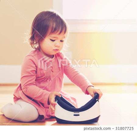 Toddler girl using a virtual reality headset Toddler girl using a virtual reality headset 31807725