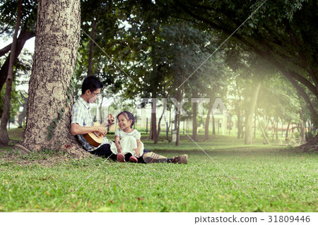 Father and child having fun play guitar together Father and child having fun play guitar together 31809446