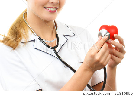Woman doctor with stethoscope examining red heart 31810990